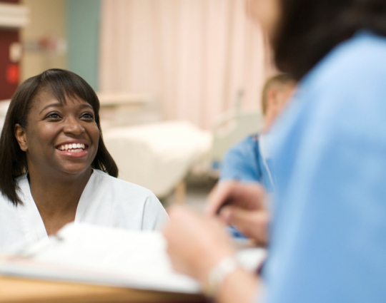 Two people talking in a hospital or medical setting 